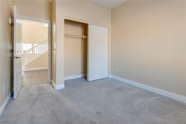 unfurnished bedroom featuring light colored carpet and a closet