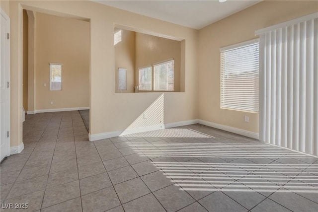 tiled spare room with a healthy amount of sunlight