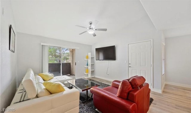 living room featuring ceiling fan, vaulted ceiling, and light wood-type flooring