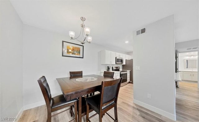 dining space featuring an inviting chandelier and light hardwood / wood-style flooring