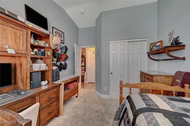 carpeted bedroom with lofted ceiling and a closet