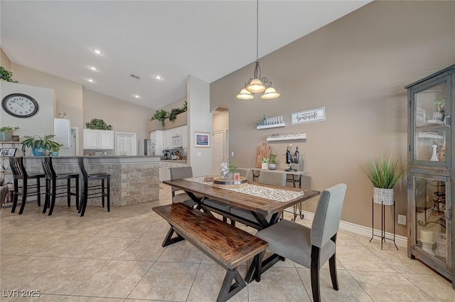 dining space with light tile patterned flooring and high vaulted ceiling