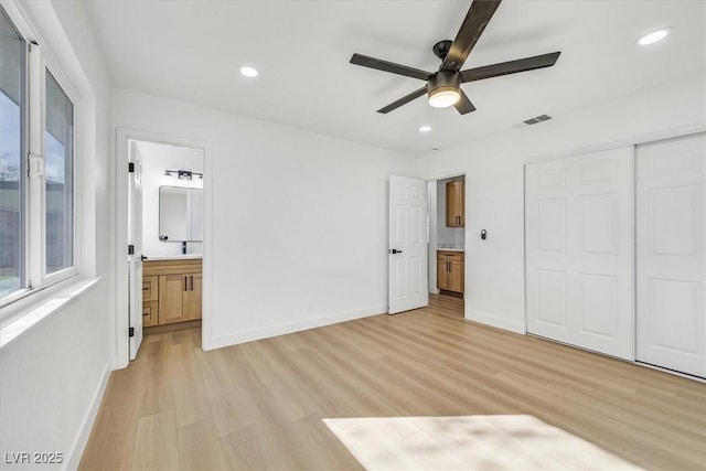 unfurnished bedroom featuring light hardwood / wood-style floors, a closet, ceiling fan, and ensuite bathroom