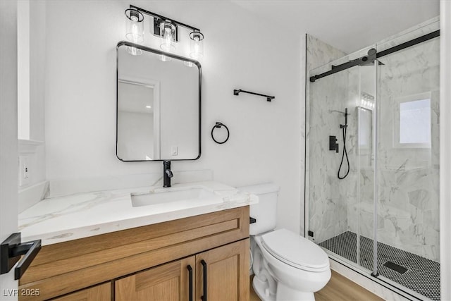 bathroom featuring vanity, walk in shower, and toilet