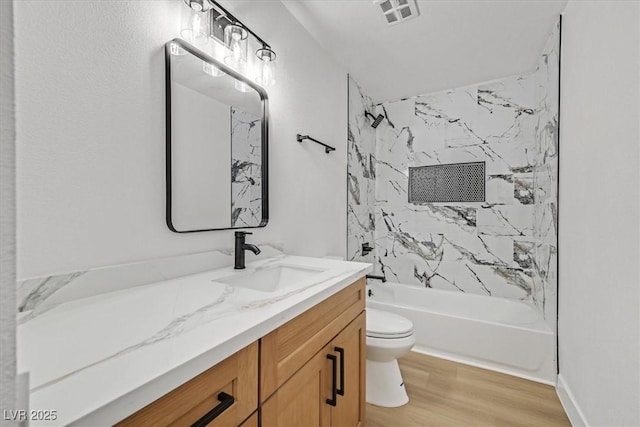 full bathroom with hardwood / wood-style flooring, vanity, toilet, and tiled shower / bath combo