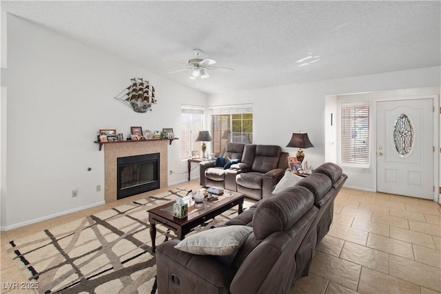 living room with lofted ceiling, plenty of natural light, a tile fireplace, and a textured ceiling