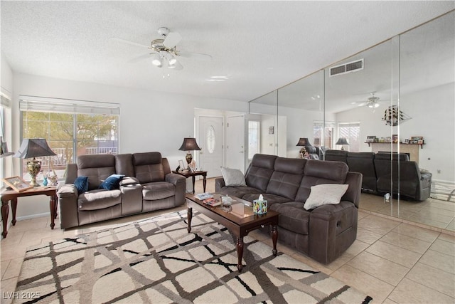 tiled living room featuring ceiling fan and a textured ceiling