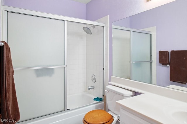 full bathroom featuring bath / shower combo with glass door, vanity, and toilet