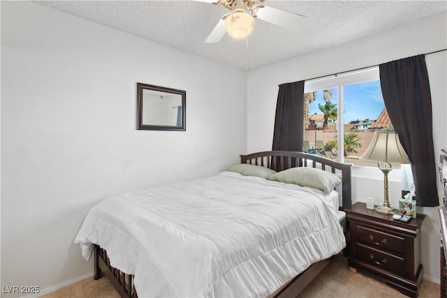 carpeted bedroom featuring ceiling fan and a textured ceiling