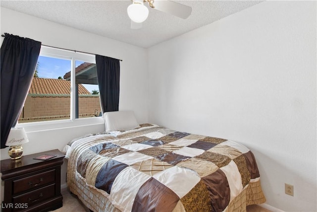 bedroom featuring ceiling fan, carpet, and a textured ceiling