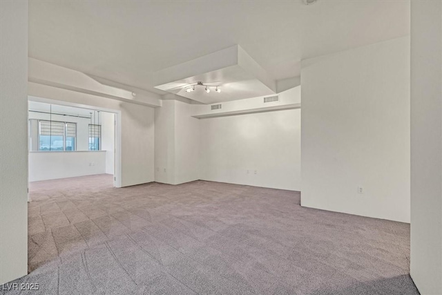 carpeted spare room featuring visible vents