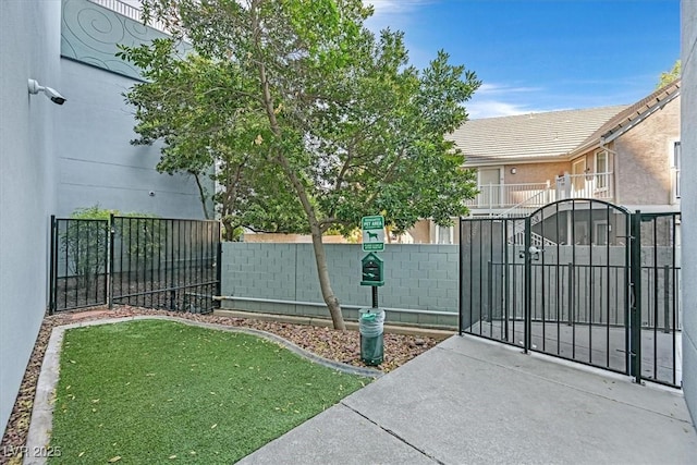 view of gate featuring a lawn and fence