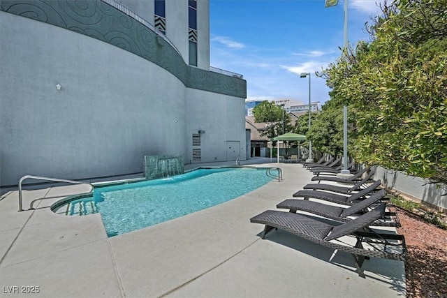 outdoor pool featuring fence and a patio