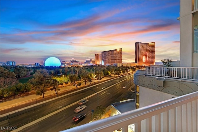 balcony at dusk featuring a city view