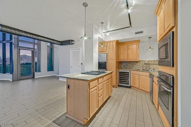 kitchen with beverage cooler, a sink, appliances with stainless steel finishes, light brown cabinetry, and pendant lighting