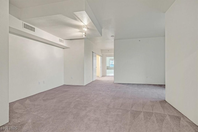 unfurnished room featuring visible vents and light colored carpet