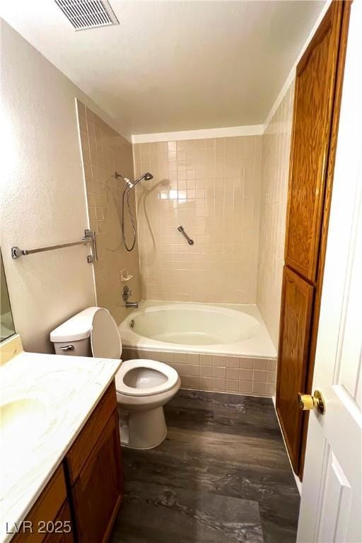 full bathroom with vanity, toilet, tiled shower / bath combo, and wood-type flooring