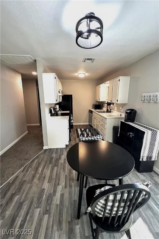 kitchen featuring white cabinetry, sink, stainless steel dishwasher, and dark hardwood / wood-style floors