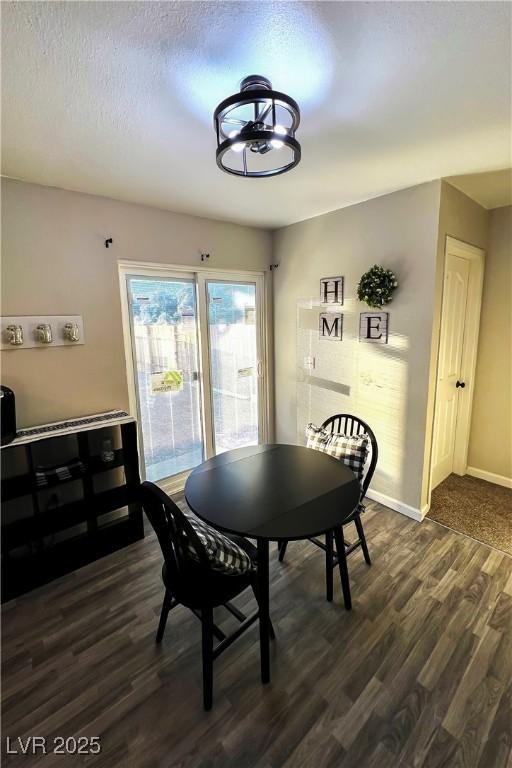 dining room with dark hardwood / wood-style floors and a textured ceiling