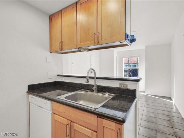 kitchen featuring a sink, white dishwasher, dark countertops, and light tile patterned flooring