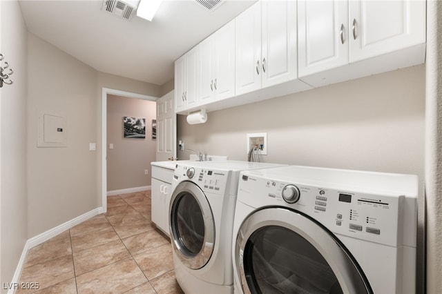 clothes washing area featuring cabinets, light tile patterned flooring, and independent washer and dryer