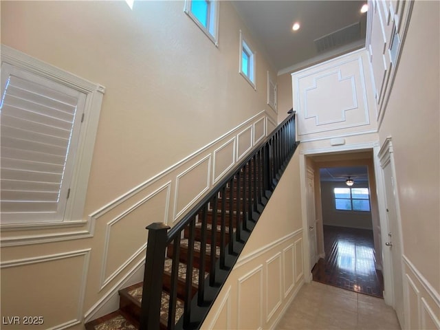 staircase featuring tile patterned floors and a high ceiling