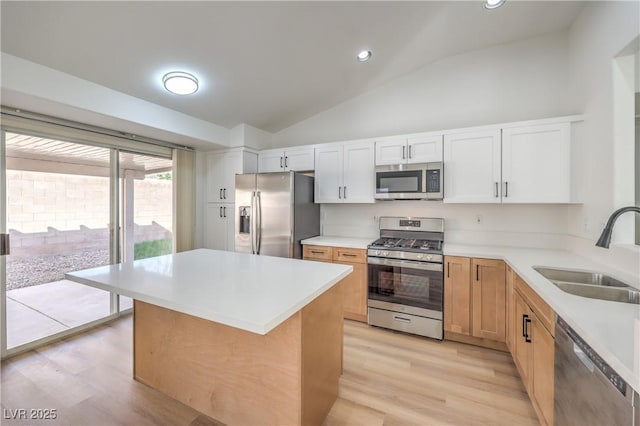 kitchen with lofted ceiling, sink, light hardwood / wood-style flooring, appliances with stainless steel finishes, and white cabinetry