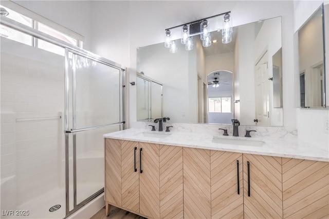 bathroom with walk in shower, ceiling fan, and vanity