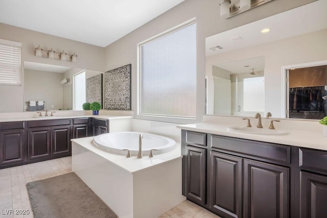 bathroom with vanity and a tub