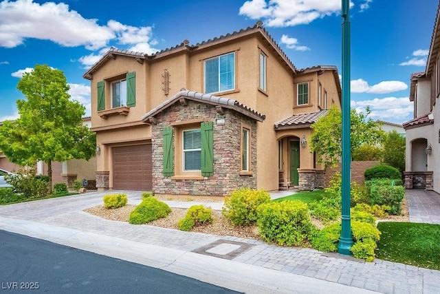 view of front facade featuring an attached garage, a tile roof, stone siding, stucco siding, and driveway