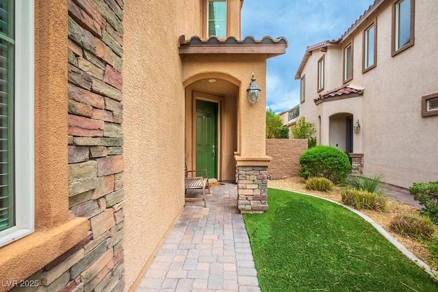 view of exterior entry with a yard