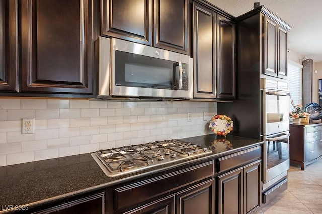 kitchen with light tile patterned floors, decorative backsplash, dark brown cabinets, and appliances with stainless steel finishes