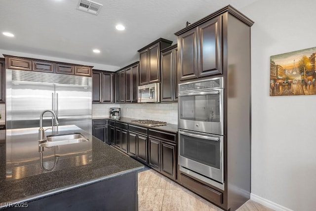 kitchen featuring tasteful backsplash, appliances with stainless steel finishes, sink, and dark brown cabinets