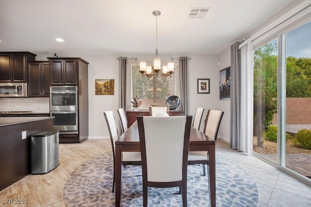 dining space with an inviting chandelier and light tile patterned floors