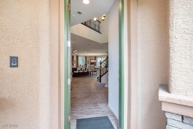 hall featuring visible vents and stairway