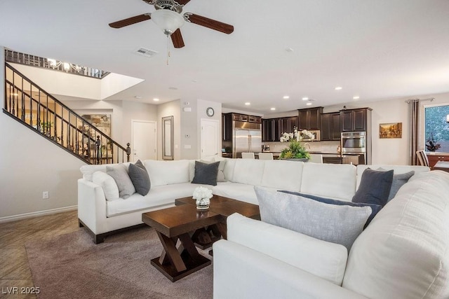 living area featuring ceiling fan, visible vents, a skylight, stairway, and recessed lighting