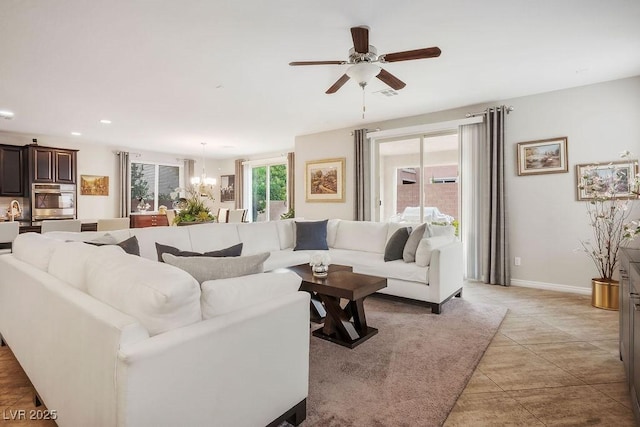 living room with ceiling fan with notable chandelier and light tile patterned floors