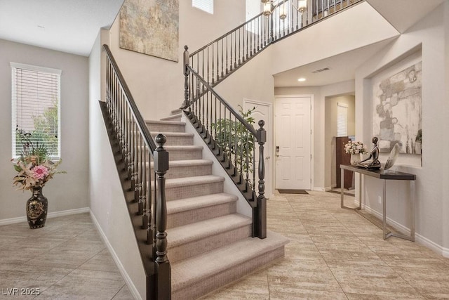 stairway featuring a towering ceiling