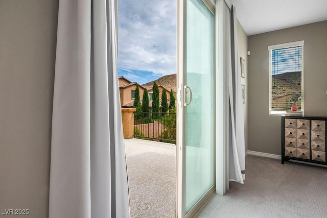 doorway to outside featuring carpet floors and baseboards