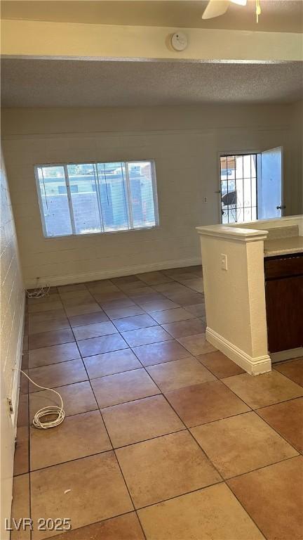 unfurnished room with light tile patterned flooring and a textured ceiling