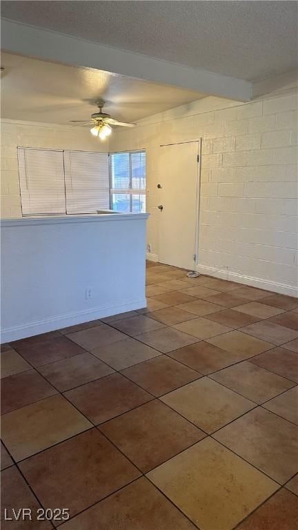 tiled spare room featuring ceiling fan and a textured ceiling