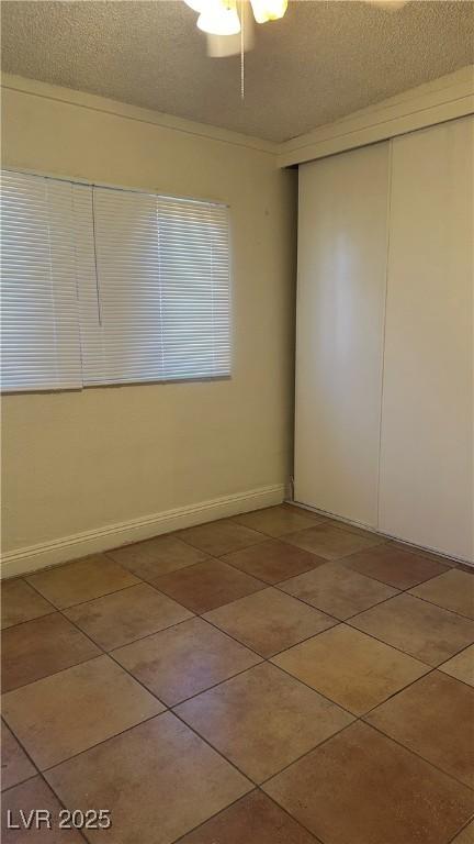 tiled spare room with a textured ceiling