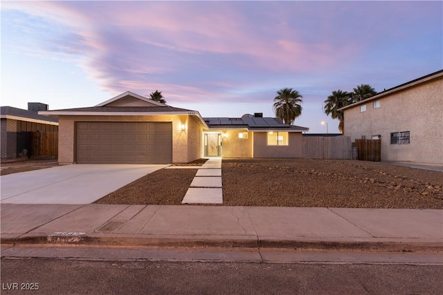 view of front of house featuring a garage and solar panels