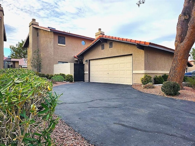 view of front of house featuring a garage, driveway, and stucco siding