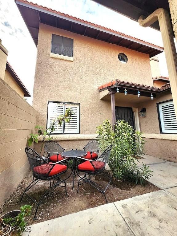 rear view of house with a patio area and stucco siding