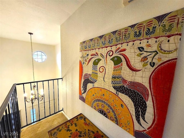 corridor featuring carpet, a textured ceiling, and an inviting chandelier