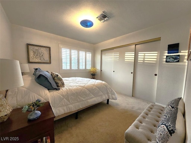 bedroom with carpet, visible vents, and a closet