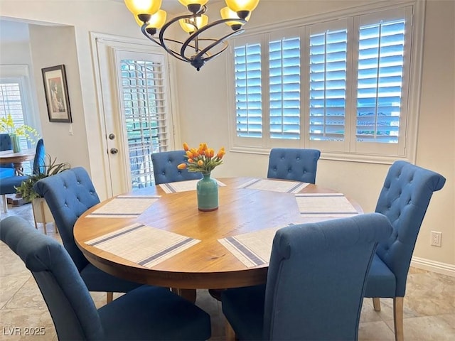 dining room with baseboards, light tile patterned floors, and a notable chandelier