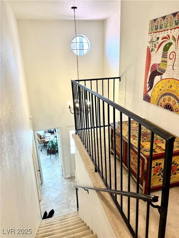 staircase featuring a high ceiling and tile patterned floors