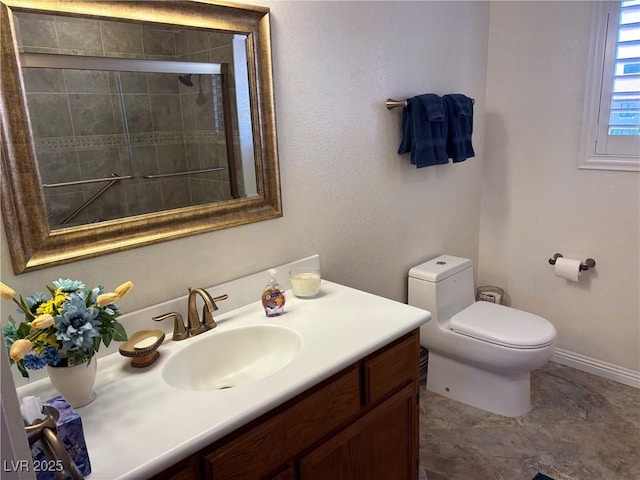 bathroom with tiled shower, vanity, toilet, and baseboards